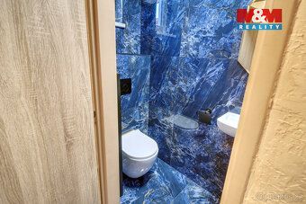 V klidné ulici v Nehvizdech stojí udržovaný řadový dům, kter