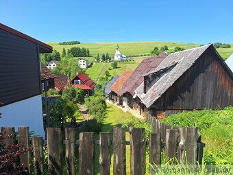 Drevenica s červenou strechou v malebnej oravskej dedine, pr