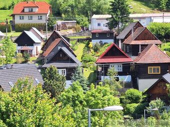 Wooden house with red roof in picturesque village of Orava, ready for immediate use.